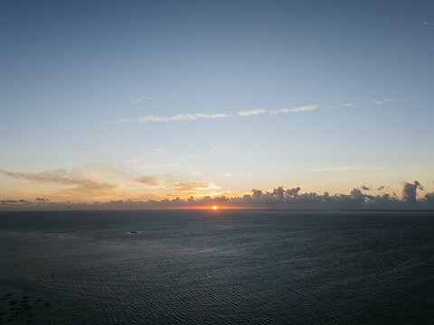 Ocean sunset horizon with clouds and calm sea
