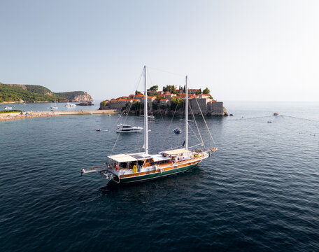 Sailing Near an Island With a Coastal Village at Sunset