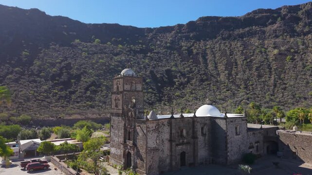 Aerial views of San Javier Mission near Loreto at sunrise highlight its historic architecture and palm trees