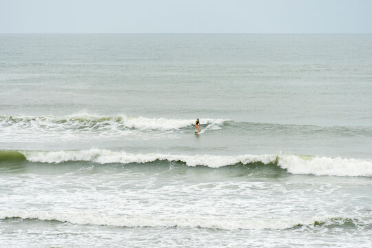 Woman doing a turn on a small wave on a cloudy day