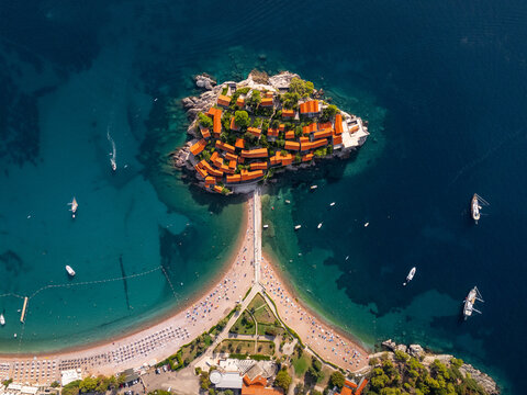 Beach and Town on Island During Sunny Day With Boats Around