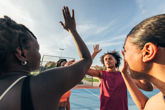 Group of people sharing high fives on a sports court