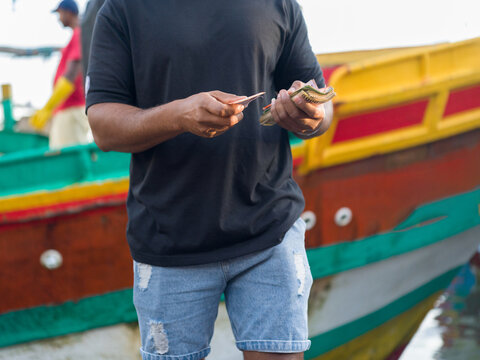 Trader Holds Cash Near at Fish Market