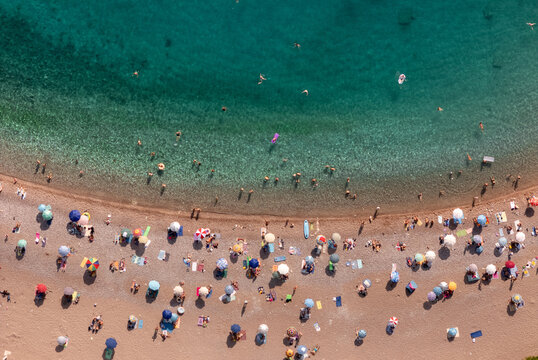 Crowd Enjoying Sun at Beach With Clear Water and Sand