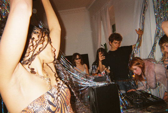 Woman dancing near DJ setup at house party