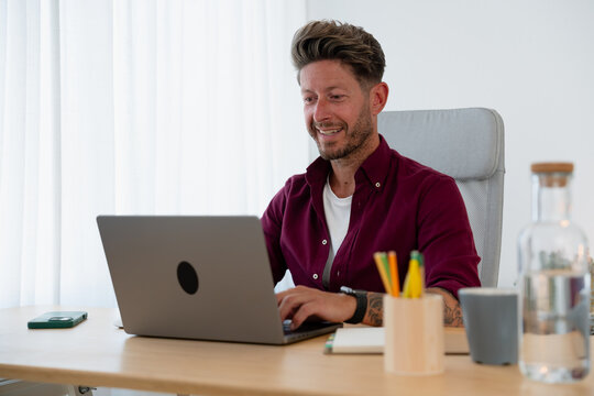 Man Working on Laptop at Home Desk