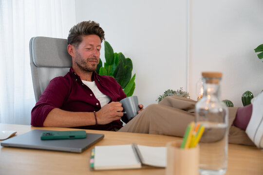 Man Relaxing with Coffee at Desk