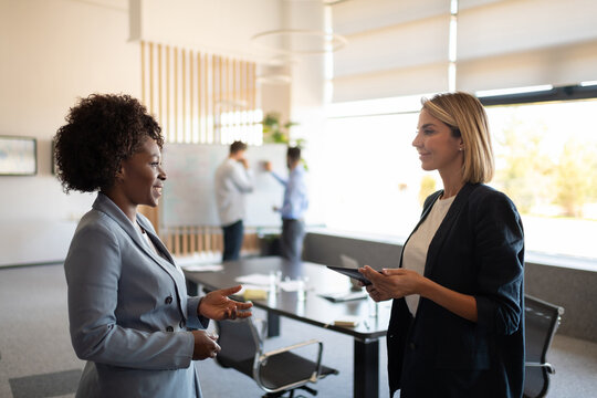 Multiethnic businesswomen speaking in office