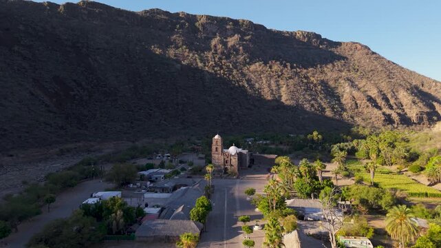 Watch as San Javier Mission comes to life at sunrise in Baja California Sur, surrounded by palm trees and mountains near Loreto
