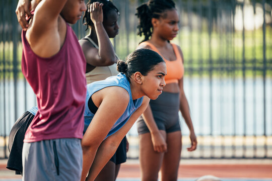 Group of determined young athletes preparing to run