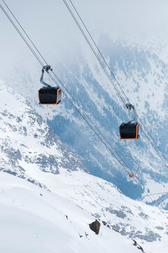 Massive cable car cabin in Tyrol with snowy mountains and fog 