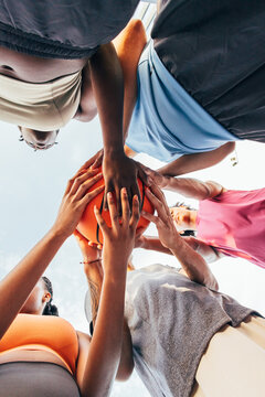 Group huddle holding basketball in teamwork concept