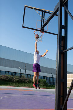 Sportsman throwing ball into hoop