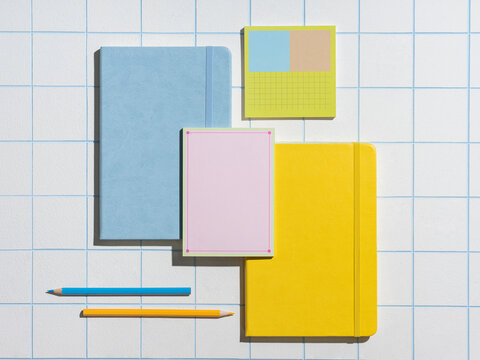 Flat lay of colorful stationery arranged on grid pattern