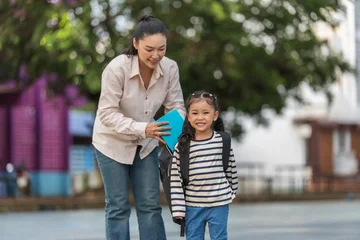 Back to school. Smiling mother and preschool student girl with backpack and book. © geargodz