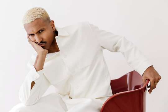 Man with mustache posing in white fashion