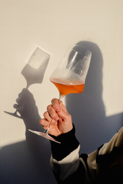 Unknown woman holding a wine glass against a white background