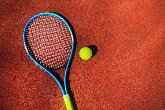 Tennis racket and ball on a tennis court.