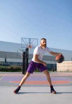 Basketball male player dribbling ball during training