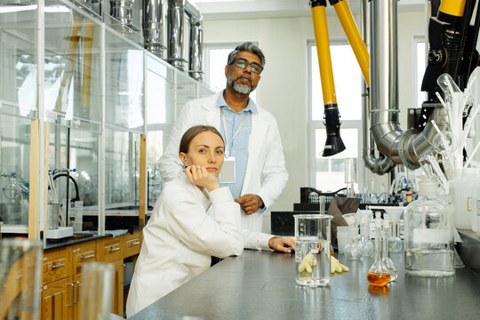 Two scientists young woman and Indian man in real laboratory