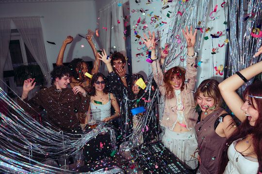 Group celebrating with confetti at indoor party