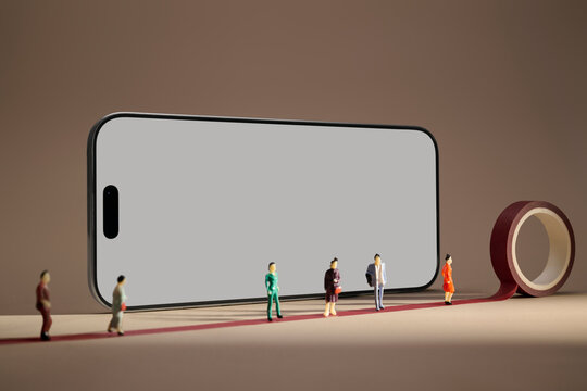 Miniature people lined up on a red carpet in front of a smartphone