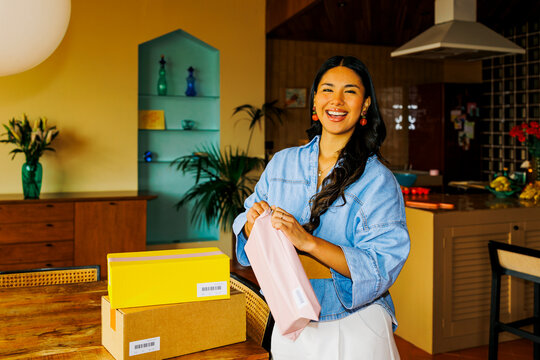 Woman opening packages at home feeling joy ugc