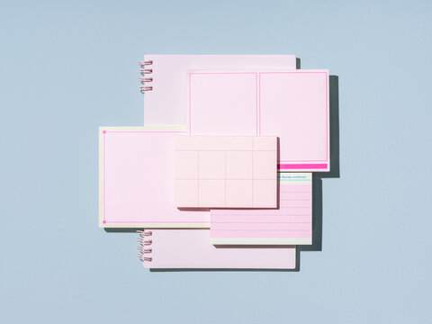 Aesthetic flat lay of pink stationery items arranged on a light blue