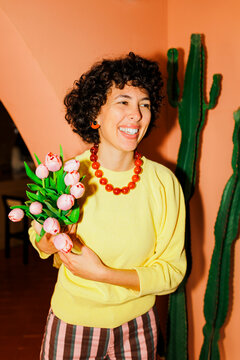 Cheerful woman holding pink tulips, celebrating happiness ugc