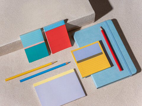 Colorful stationery items including notebooks, sticky notes and pen