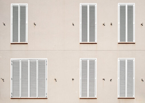 Abstract building wall and windows with closed shutters