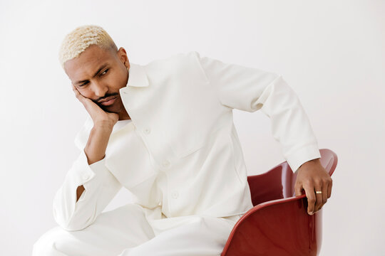 Man sitting on red chair looking down