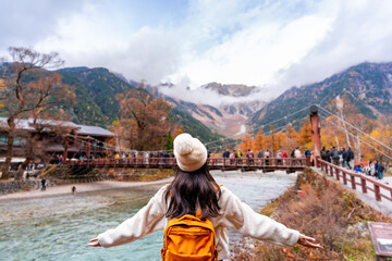 Young solo female traveler enjoying a beautiful autumn day and stunning nature landscape while exploring Kamikochi National Park © Kittiphan