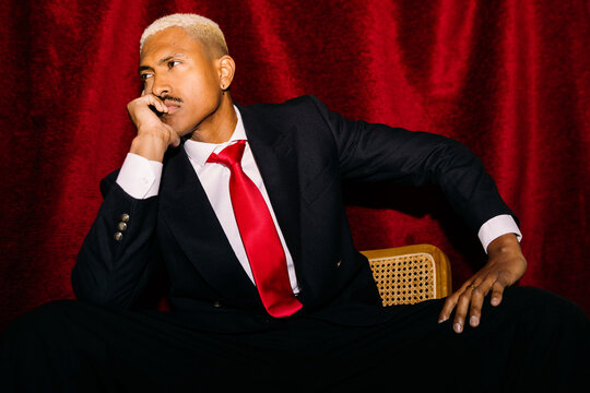 Elegant man against red curtain