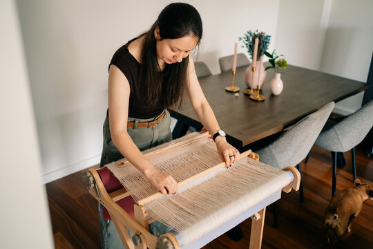 Woman Weaves Fabric at Home During the Afternoon