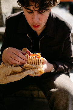 young man eating street food in the city of Lyon France