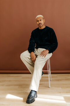 Man sitting on stool wearing black sweater