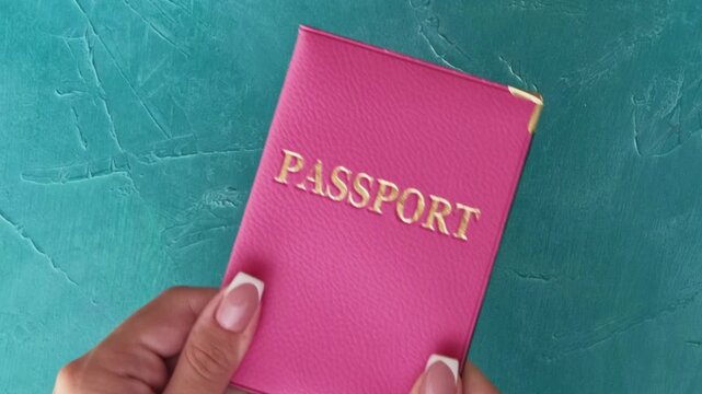 Airport check-in. Travel safety. Immigration officer hand in protective glove taking female passenger passport in pink cover on blue set of 4 loop.