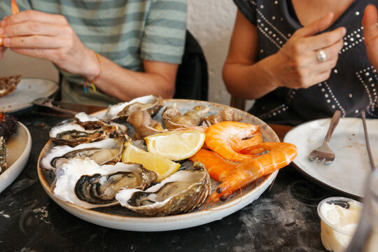 Friends Enjoy Seafood With Oysters. France