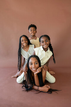 Children Pose Together in Studio Setting on Brown Backdrop