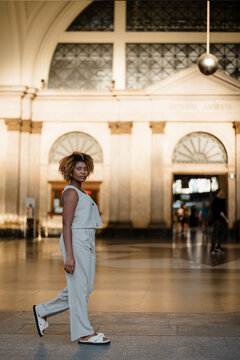 A woman walking in front of the train station