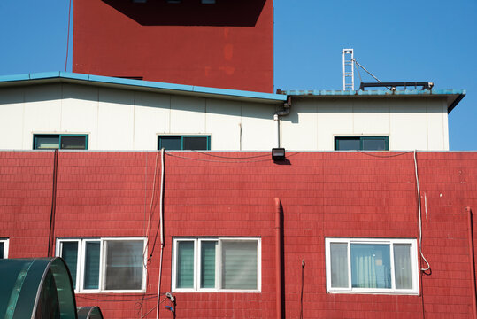 Vibrant Red Terracotta Brick Building Facade Against a Clear Blue Sky