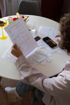Person organizing home finances calculating monthly expenses