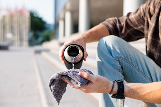 Man wetting towel to cool down during urban heatwave