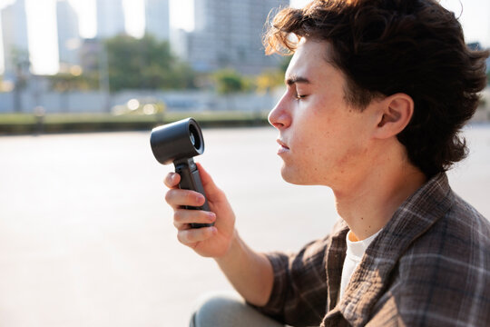 Man using handheld fan to cope with extreme heat