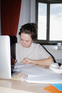 Person studying and writing notes at home desk