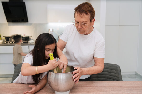 Grandmother and Kids Make Cake Together in the Kitchen for Fun
