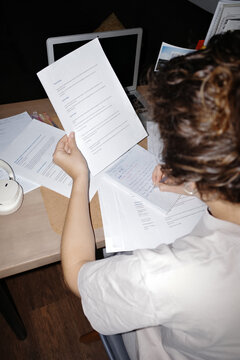 Person studying holding document and writing notes