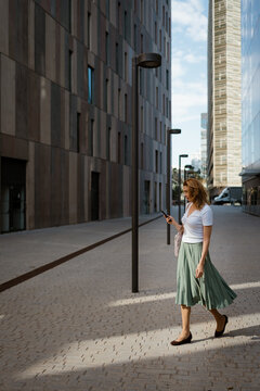 A woman uses a mobile phone while walking to the office