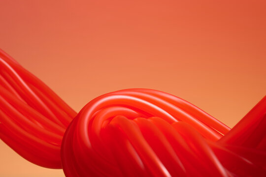 Vibrant red licorice twists forming an abstract shape against a red